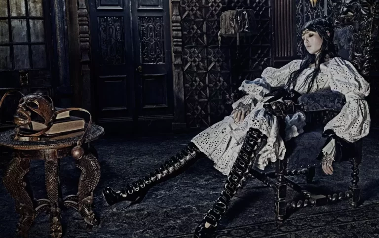 Campagna di Alexander McQueen con una donna seduta in un ambiente e con abbigliamento "Medievale".
